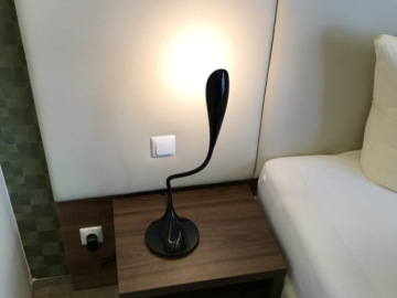 Nočný stolík doplnený o dizajnovú lampu.
